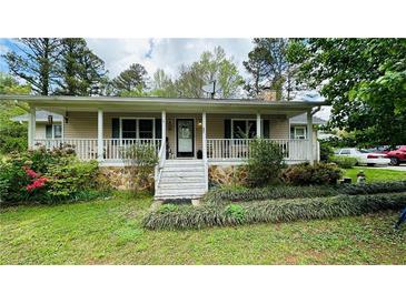 Charming home features a welcoming front porch, stone accents and beautiful landscaping at 661 Winndale Rd, Dallas, GA 30157