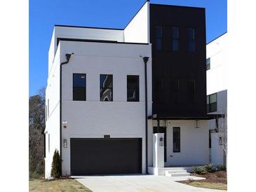 Modern two-story home featuring black trim, a gray garage door, and a neutral paint scheme at 1420 Coretta Bend, Atlanta, GA 30318