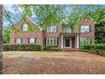 Two-story brick home with dark shutters and a covered front porch framed by white columns at 732 Sweet Gum Way, Canton, GA 30115