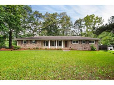 Charming brick ranch-style home with a well-manicured lawn and mature trees at 2729 Lanier Dr, Snellville, GA 30078