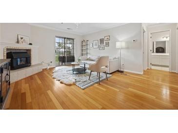 Bright living room with fireplace, wood floors, and sliding doors to a balcony at 970 Sidney Marcus Ne Blvd # 2403, Atlanta, GA 30324