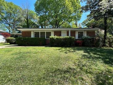Charming one-story brick home with a green lawn and manicured shrubs in a lush neighborhood at 779 Casplan Sw St, Atlanta, GA 30310