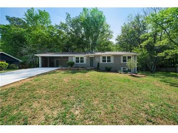 Charming single-story home featuring a long driveway, carport, and well-maintained front lawn at 830 Lee Nw Dr, Marietta, GA 30060
