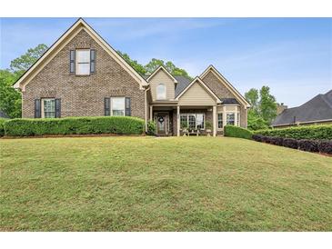 Charming brick home featuring a manicured lawn and welcoming front porch at 2656 White Rock Dr, Buford, GA 30519