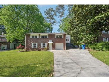 Charming brick home with a well-manicured lawn and long driveway at 2911 Allegro Nw Dr, Atlanta, GA 30318