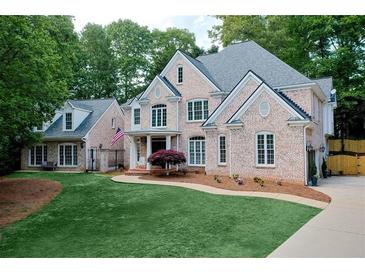 Charming two-story brick home featuring a lush green lawn, mature trees, and inviting curb appeal at 2930 Burnt Hickory Nw Rd, Marietta, GA 30064