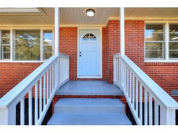 Inviting brick home with a white front door and freshly painted gray steps leading to a cozy, covered porch at 4551 Salem Rd, Covington, GA 30016