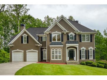 Stunning two-story home featuring a meticulously manicured lawn and a convenient two-car garage at 5595 Timson Ln, Johns Creek, GA 30022