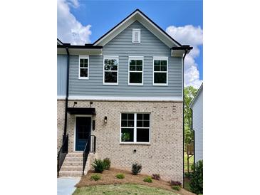 Beautiful townhome featuring a charming brick facade and stylish blue siding at 1230 Ainsworth Aly # 34, Sugar Hill, GA 30518