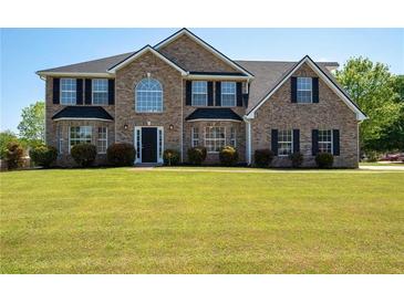 Two-story brick home with a well-manicured lawn and black shutters on the windows at 9482 Deer Crossing Ln, Jonesboro, GA 30236