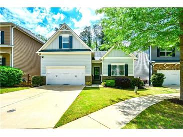 Charming home features a two-car garage, manicured lawn, and inviting curb appeal at 973 Duncan Ter, Canton, GA 30115