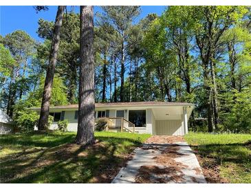 Charming exterior featuring light-colored brick and lush surrounding trees at 3706 Larkspur Ter, Decatur, GA 30032