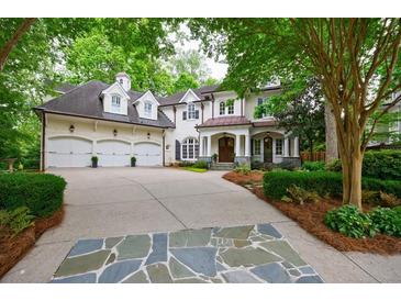 Stunning white brick home featuring a three-car garage and beautifully landscaped front yard at 1412 Lanier Ne Mnr, Atlanta, GA 30319