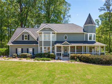Charming two-story home features a turret, covered porch, beautiful landscaping, and a well-maintained lawn at 4013 Dover Ave, Alpharetta, GA 30009