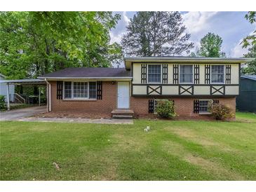 Charming split-level home featuring a well-maintained lawn and traditional brick and siding accents at 8431 Magnolia Dr, Jonesboro, GA 30238