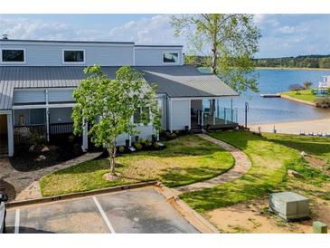 Waterfront condo with a sandy beach area and a well-maintained lawn at 277 Clearview Ct, Villa Rica, GA 30180