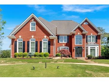 Stately red brick home with manicured lawn and mature landscaping at 3265 Belmont Glen Se Dr, Marietta, GA 30067