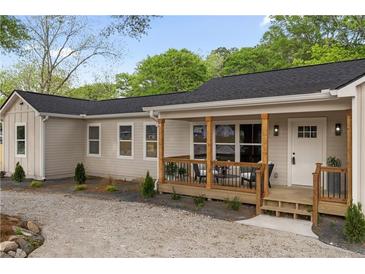 Charming one-story home with a cozy front porch featuring a seating area, perfect for relaxing outdoors at 1835 Hawkins Se St, Smyrna, GA 30080