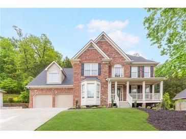 Traditional two-story brick home with a landscaped front yard and covered porch at 1342 Winborn Nw Cir, Kennesaw, GA 30152