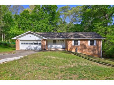 Charming brick home with an attached garage and a well-maintained front lawn at 3341 Rae Pl, Lawrenceville, GA 30044