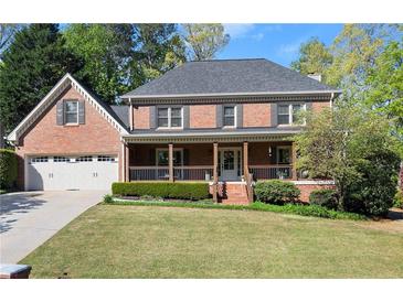 Charming two-story brick home with a welcoming front porch and manicured lawn at 2040 Parliament Dr, Lawrenceville, GA 30043