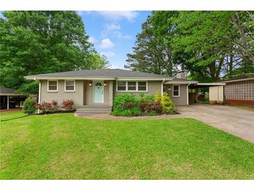 Charming single-story home with a well-manicured lawn, mature trees, and a quaint light-blue front door at 975 Shirley Se St, Smyrna, GA 30082