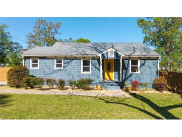 Charming blue single-story home featuring a bright yellow front door and manicured landscaping at 1961 Addison Ne Rd, Marietta, GA 30066