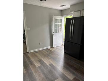 Bright kitchen features hardwood floors and a modern, black refrigerator near the back door at 2919 Cushing Ct, Jonesboro, GA 30238
