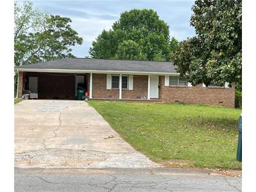 Charming single story brick home with attached carport and a well maintained lawn at 6192 Meadowbrook Dr, Norcross, GA 30093