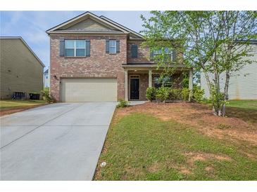 Charming two-story brick home with a well-maintained lawn and an attached two-car garage at 1003 Eldon Ln, Fairburn, GA 30213