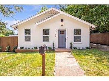 Charming home featuring a manicured lawn, attractive gray front door, and a welcoming facade at 2294 Hill Nw St, Atlanta, GA 30318