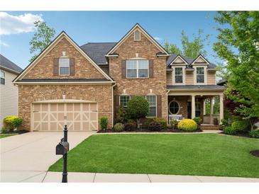 Charming brick home with a well-manicured lawn, two car garage, and inviting front porch at 280 Lakestone Pkwy, Woodstock, GA 30188