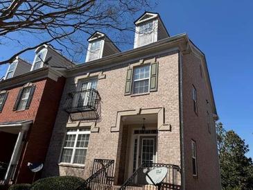 Charming multi-level townhome with brick facade and dormer windows under a clear blue sky at 308 Holbrook Rd # Bldg 11, Smyrna, GA 30082