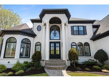 Stunning white and black two-story home with an elegant entryway and manicured landscaping at 1015 Bedford Gardens Dr, Alpharetta, GA 30022