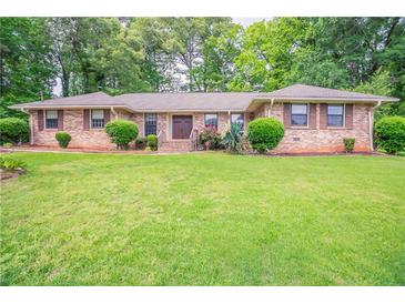 Charming brick home features a lush front lawn and mature landscaping for great curb appeal at 2020 Buckingham Ct, Decatur, GA 30035