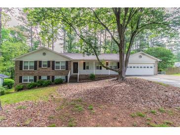 Charming brick home with a well-manicured front yard and inviting front porch at 2814 Brackenwood Dr, Snellville, GA 30039