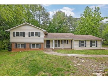 Charming split-level home with a well-manicured lawn and mature trees providing shade at 1008 Hope Springs Ct, Stone Mountain, GA 30083