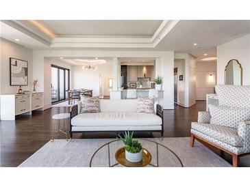 Bright living room featuring a stylish sofa, hardwood floors, and open layout with a kitchen view at 3475 Oak Valley Ne Rd # 2940, Atlanta, GA 30326