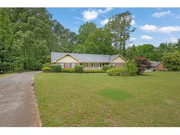 Ranch-style home with large front yard, mature trees, and inviting curb appeal at 5309 Ashley Se Dr, Conyers, GA 30094