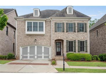 Charming two-story brick home with a well-manicured lawn and attached two-car garage at 6265 Bellmoore Park Ln, Johns Creek, GA 30097