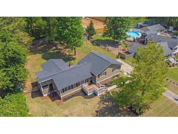 An exterior shot featuring a two-story house with a porch and a well maintained lawn and backyard pool at 6470 Windsor Dr, Acworth, GA 30102