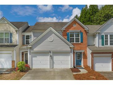 Charming townhome featuring a combination of brick and siding and a two-car garage at 4205 Royal Regency Nw Cir, Kennesaw, GA 30144