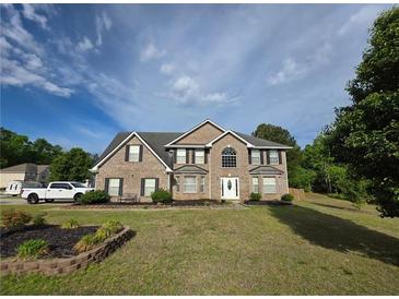 Inviting two-story brick home with manicured lawn and classic architectural details at 6948 Dalehollow Dr, Lithonia, GA 30058