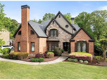 Charming two-story home featuring a brick and stone facade, beautiful landscaping, and a welcoming front entrance at 1062 Meadow Grass Ln, Powder Springs, GA 30127
