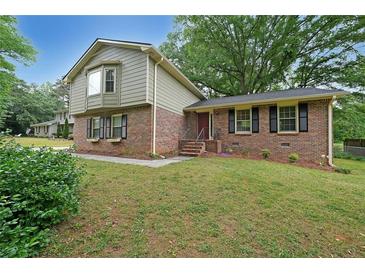 Charming brick home with a well-manicured lawn and lovely curb appeal at 387 Cascade Sw Dr, Lilburn, GA 30047