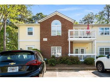Multi-level condo building with cream siding, brick accents, and private balconies at 4337 Orchard Park Ct, Stone Mountain, GA 30083