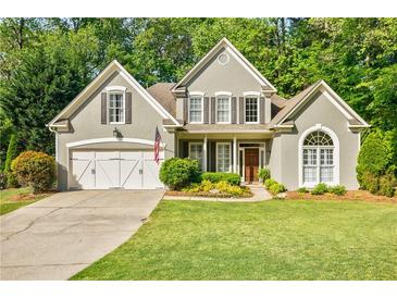 Charming two-story home with a well-manicured lawn, inviting entrance, and attached two-car garage at 7155 Hartsfield Pl, Suwanee, GA 30024