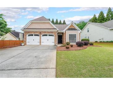 Charming single-story home featuring a well-manicured lawn, stone accents, and a two-car garage at 905 Downyshire Dr, Lawrenceville, GA 30044