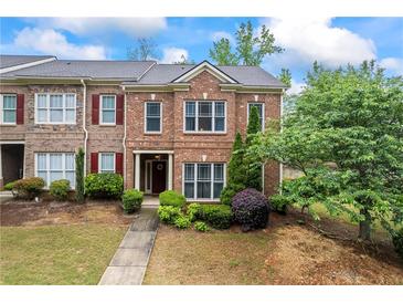 Charming brick townhome with red shutters and manicured landscaping at 168 Constitution Blvd # 12, Lawrenceville, GA 30046