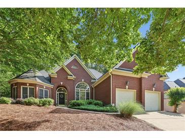 Charming brick home with a two-car garage and lush landscaping at 378 Rhodes House Dr, Suwanee, GA 30024